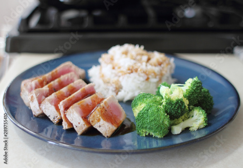 Ahi tuna sliced thin with teriyaki demi-glace, served with rice and broccoli.