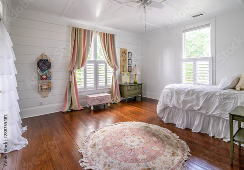 Bedroom in Old House with wood floors Pink and White Bedspread and Original shiplap