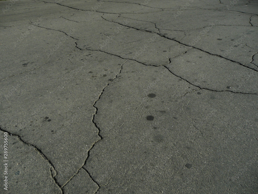 Obraz premium The asphalt is covered in cracks from poor quality work.
