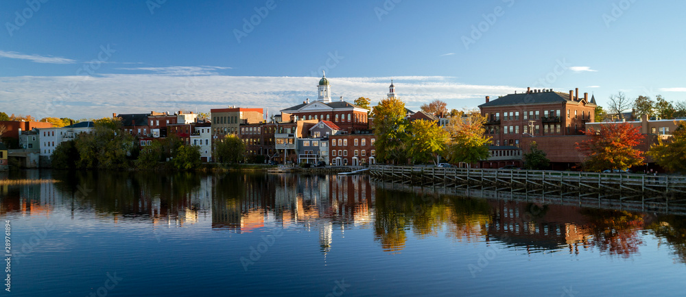 Naklejka premium The river front buildings of Exeter, New Hampshire are seen reflected in the water