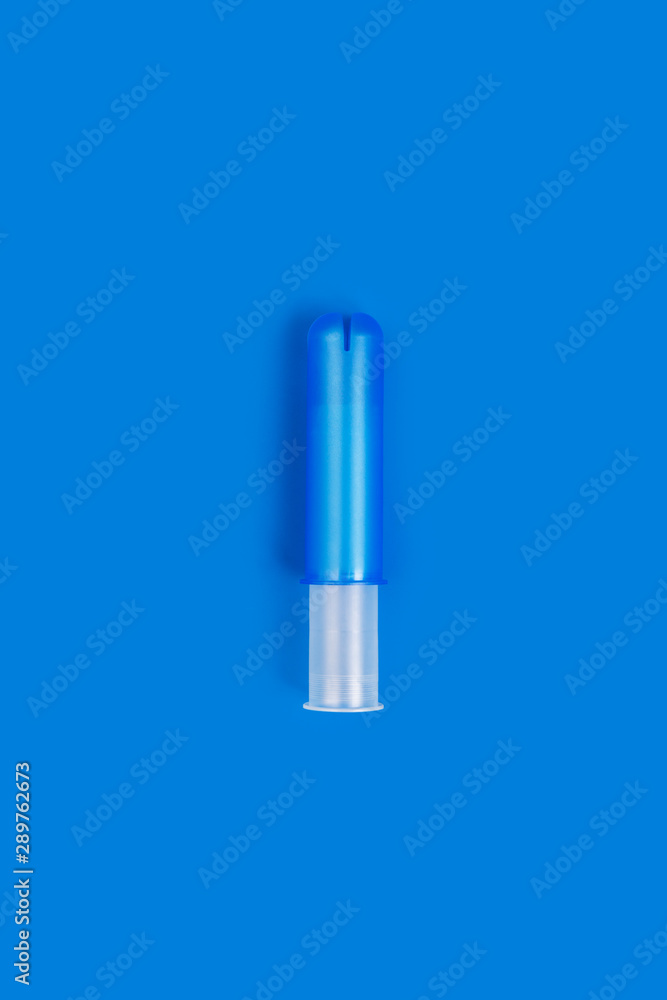 Empty blue plastic tampon applicator isolated on vivid blue background