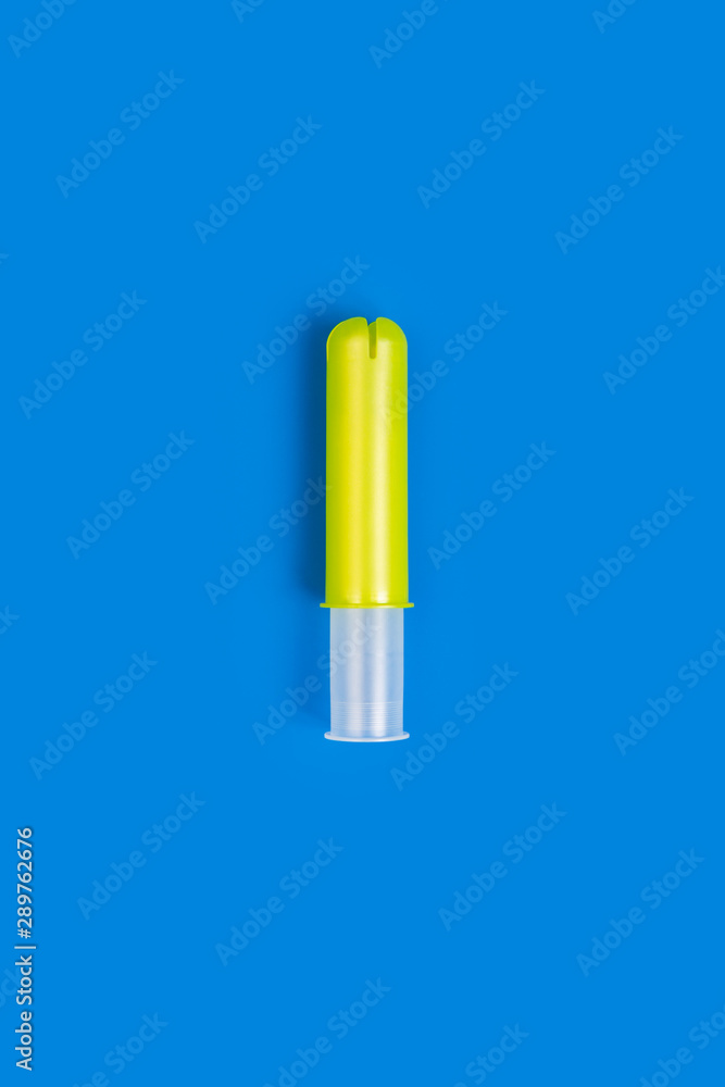 Empty yellow plastic tampon applicator isolated on vivid blue background  Stock Photo | Adobe Stock