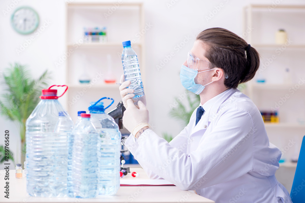 Young male chemist experimenting in lab Young male chemist experimenting in lab