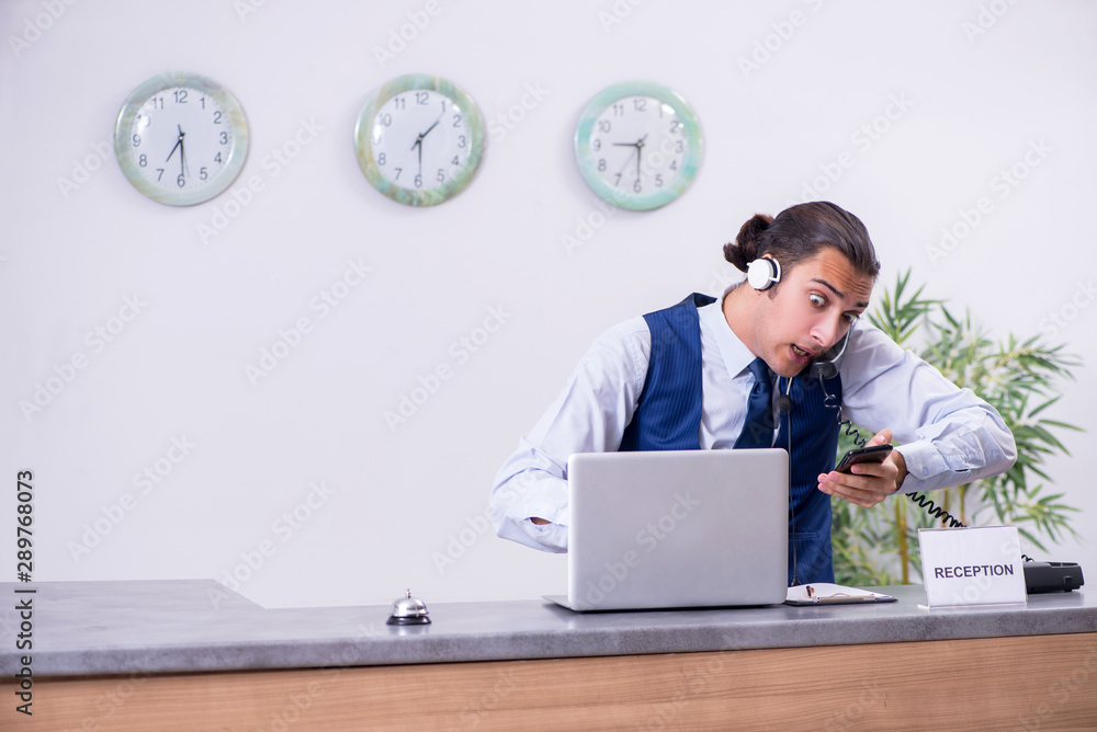 Young man receptionist at the hotel counter Young man receptionist at the hotel counter