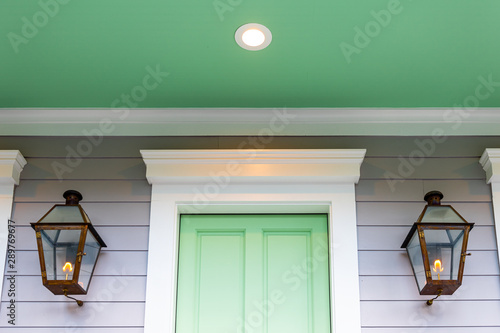 фотографія Closeup of green and white door entrance of home or house architecture detail in