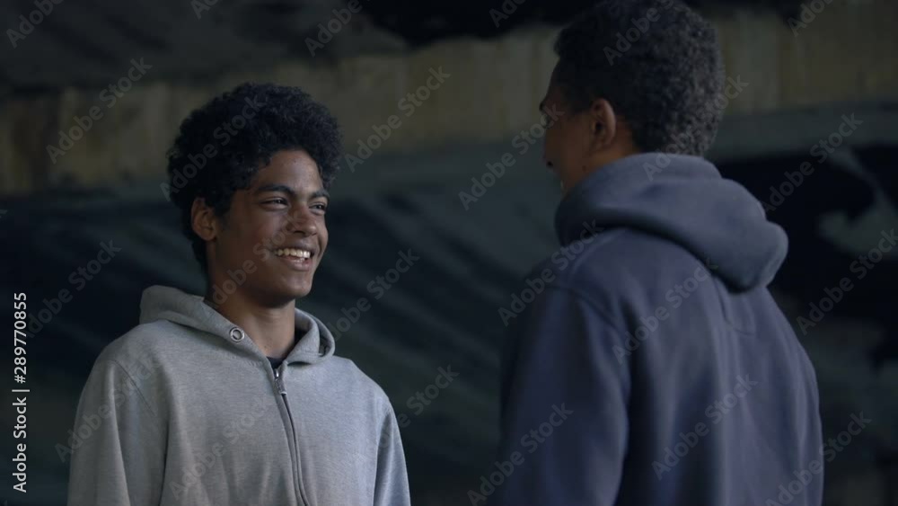 Cheerful college student fist bumping, teenage communication gesture, friends Cheerful college student fist bumping, teenage communication gesture, friends