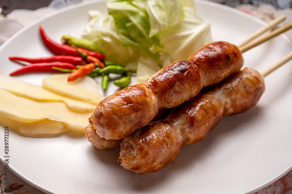 Northeastern Sausage , Isan pork sausage recipe , Isaan pork sausage recipe on a white plate with a side dish