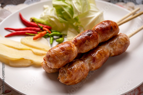 Northeastern Sausage , Isan pork sausage recipe , Isaan pork sausage recipe on a white plate with a side dish