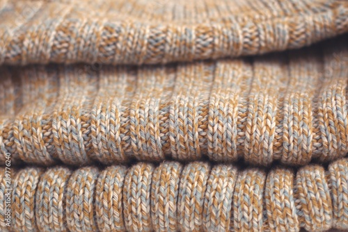 Mottled beige knitted sweater. Texture detail close up.