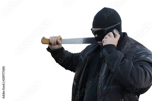 bandit with a machete in a black mask talking on the phone on an white isolated background