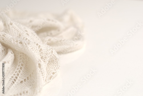 Ivory color crochet sweater on white background. Texture detail close up.