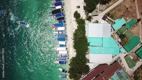 Top view of Phi Phi Island during lunch time, when all the boats stop by the beach for tourists on a day trip. 4k drone footage of one of the most famous islands in Thailand.