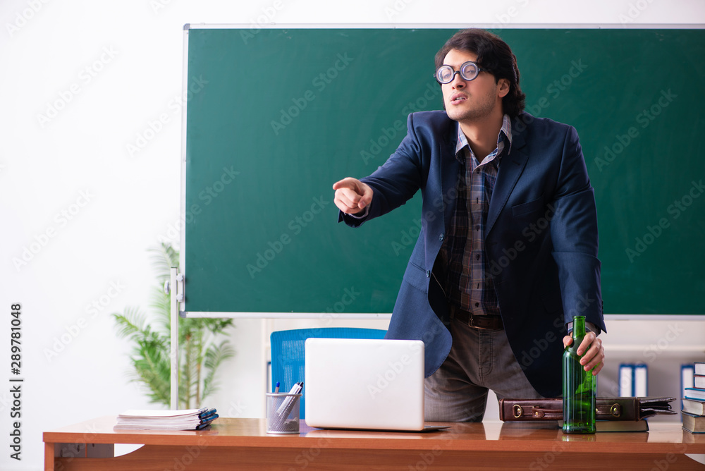 Male teacher drinking in the classroom Male teacher drinking in the classroom
