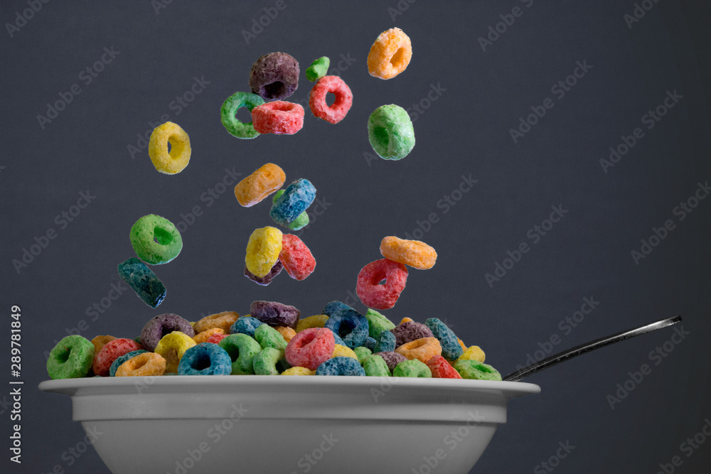 Colorful round cereal in mid air being poured into bowl