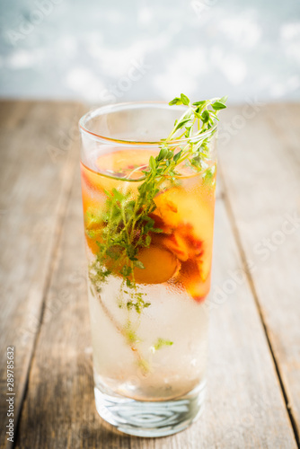 Gin based cocktail with peaches and thyme. Selective focus. Shallow depth of field.