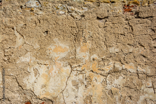 Very old, very cracked stone wall with remains of brickwork