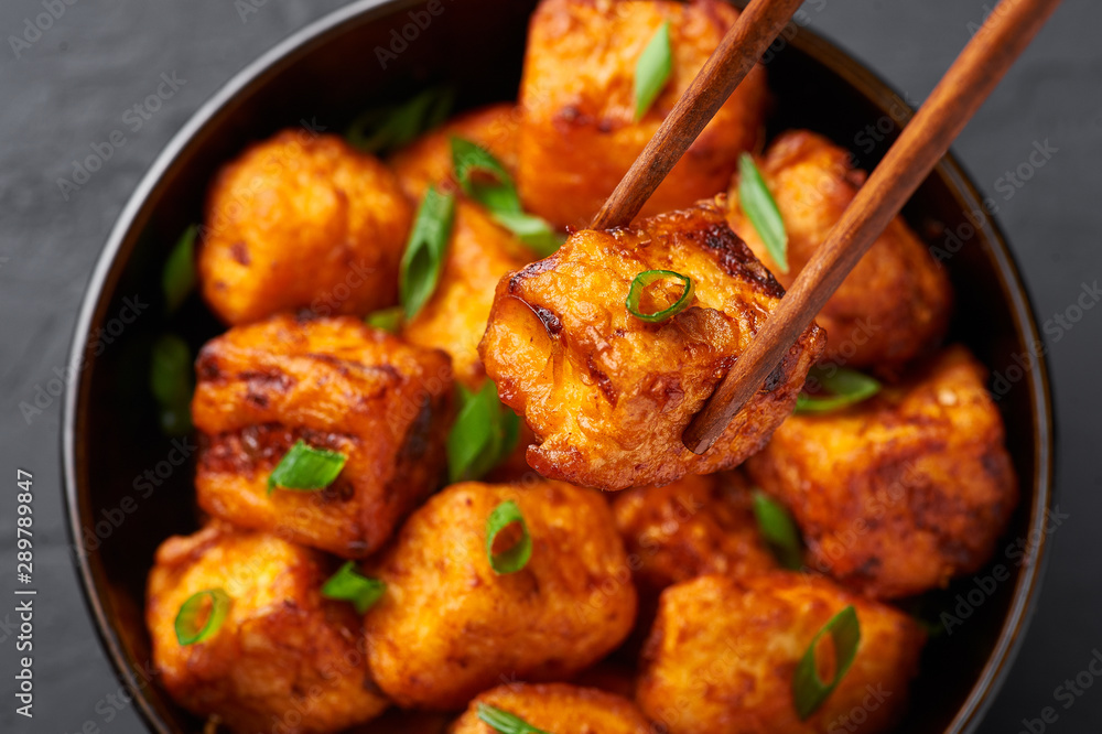 Paneer Manchurian or Paneer 65 in bowl at black concrete background. Paneer Manchurian is Indian Chinese cuisine dish with panner cheese, tomatoes, onion, soy sauce. Close Up Paneer Manchurian or Paneer 65 in bowl at black concrete background. Paneer Manchurian is Indian Chinese cuisine dish with panner cheese, tomatoes, onion, soy sauce. Close Up