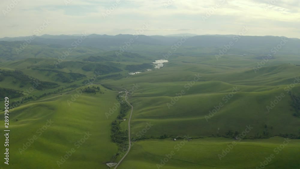 4K resolution, aerial drone at 29 frames per second over mountain in National Park with cloudy skies. Road through the hills. 4K resolution, aerial drone at 29 frames per second over mountain in National Park with cloudy skies. Road through the hills.