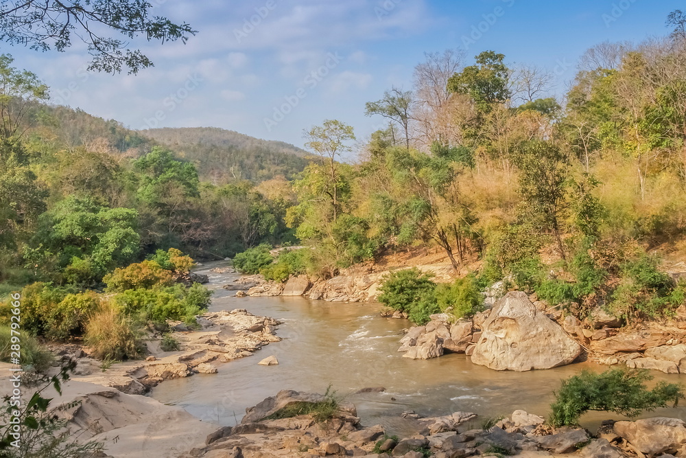 view of river flowing around with many arch rocks and green forest with the hills and blue sky background, Ob Luang National Park, Chiang Mai, northern of Thailand.
