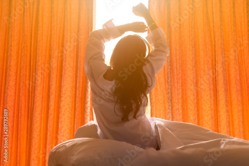 Young happy woman wake up in the morning in the bedroom in the happy smile. Concept woke up..