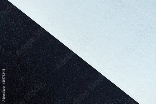 Multicolored sheets of paper on a dark leather background close up