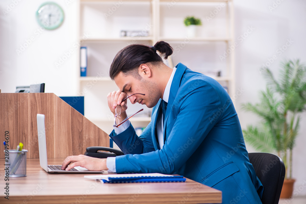 Naklejka premium Young handsome businessman sitting in the office
