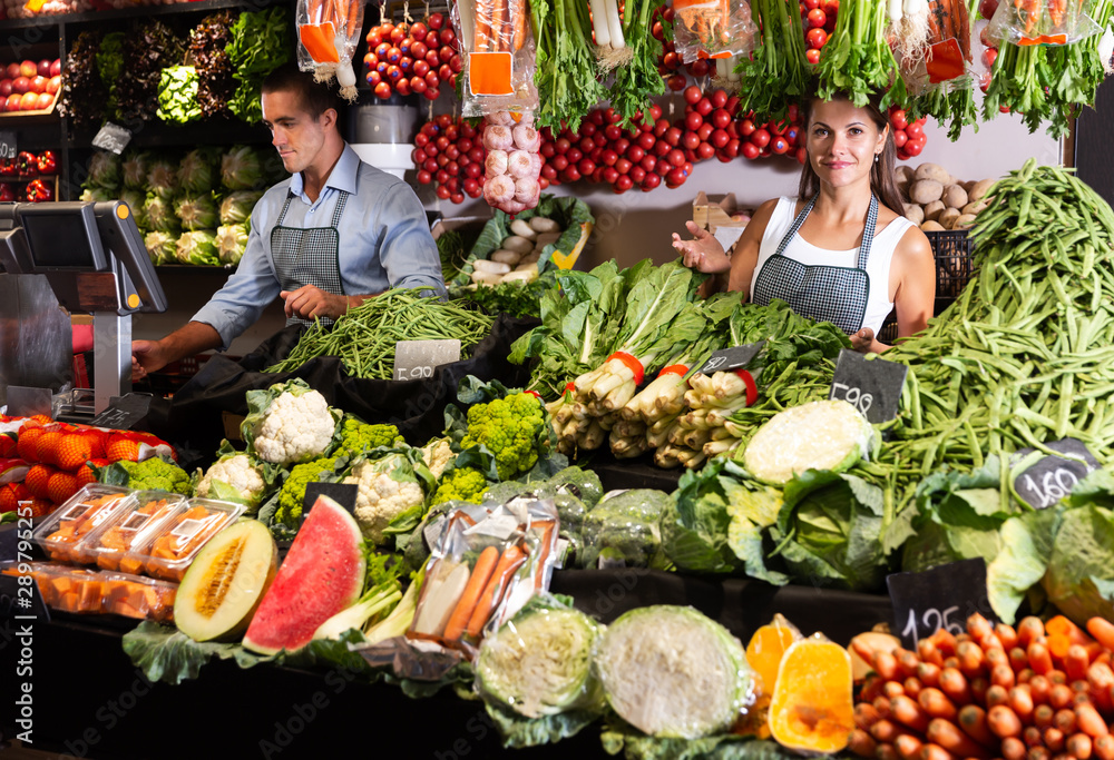 Female seller offering vegetables on market