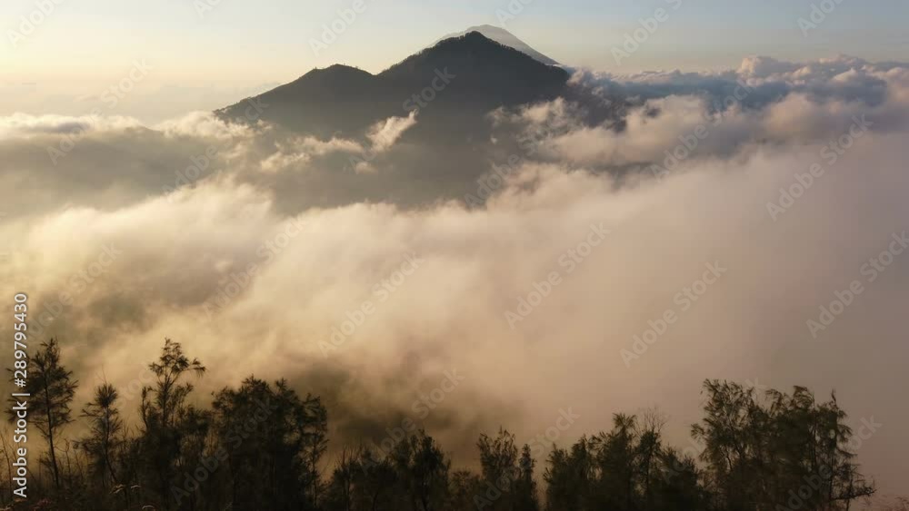 Scenic view of clouds and mist at sunrise from the top of mount Batur (Kintamani volcano), Bali, Indonesia Scenic view of clouds and mist at sunrise from the top of mount Batur (Kintamani volcano), Bali, Indonesia