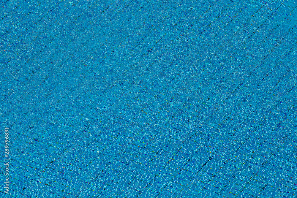Water ripples on blue tiled swimming pool background. View from above. Water ripples on blue tiled swimming pool background. View from above.