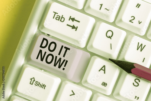 Conceptual hand writing showing Do It Now. Concept meaning not hesitate and start working or doing stuff right away White pc keyboard with note paper above the white background