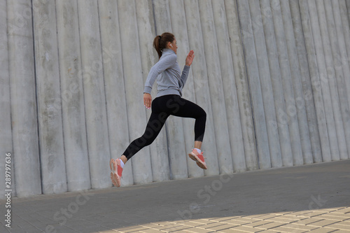 Young attractive woman with perfect slim body running outdoors. Fitness and running concept