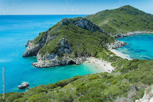 Porto TImoni beach in Corfu, Greece. Double beach surrounded by azure turquoise sea and green rocky scenery. Afionas and Agios Georgios Pagon town district.