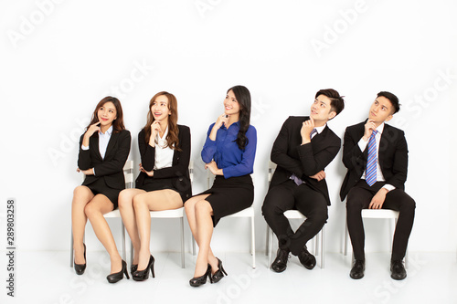 asian business people sitting on the chairs in a row
