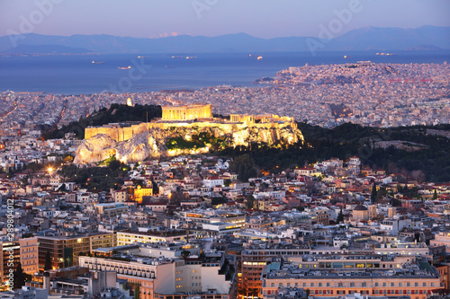 Cityscape of Athens with illuminated Acropolis hill, Pathenon and sea at night, Greece photo