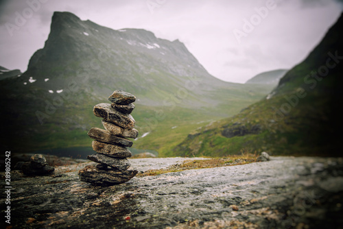 Bild auf Leinwand A cairn of stones on a background of mountains, an amazing landscape in the moun