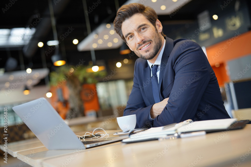 Fototapeta premium Businessman working on laptop while waiting for client