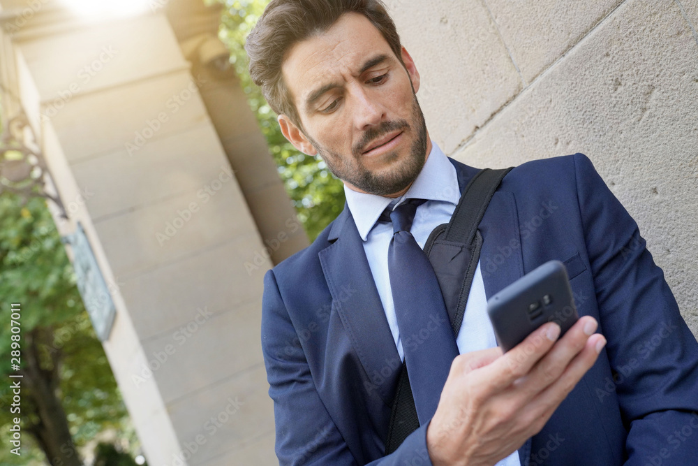 Businessman in the street using smartphone Businessman in the street using smartphone