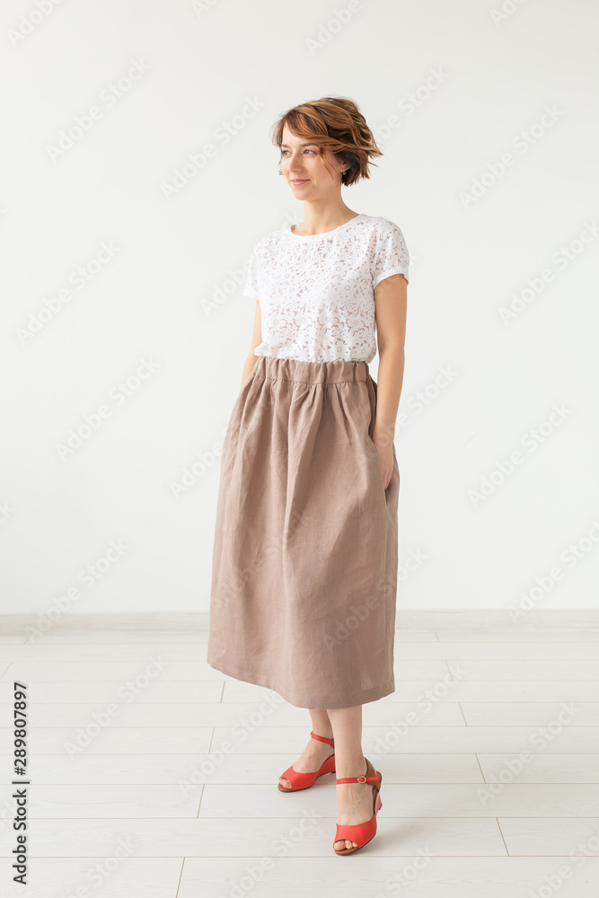 people, fashion and style concept - young woman posing in clothes in studio on white background. people, fashion and style concept - young woman posing in clothes in studio on white background.