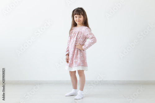 model, clothing designer, people concept - little girl model in pink dress over the white background
