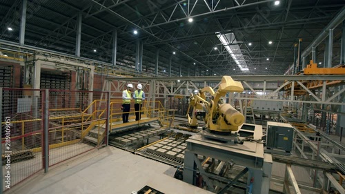 Two engineers working at modern factory floor photo