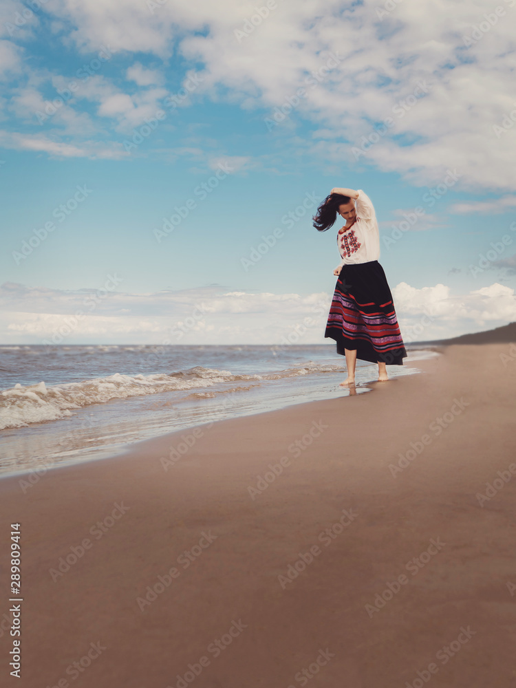 Beautiful girl in national dress on the shore of the Baltic Sea. Retro photography. Restoring the atmosphere of the Middle Ages. Rest, relaxation, vacation. Beautiful girl in national dress on the shore of the Baltic Sea. Retro photography. Restoring the atmosphere of the Middle Ages. Rest, relaxation, vacation.