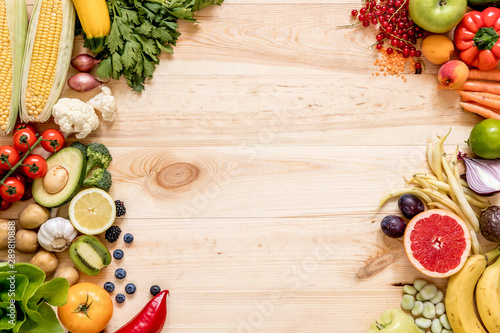 Modern composition of fresh healthy vegetables and fruits on the wooden table in the kitchen. Healthy detox and balance diet. Lifestyle. Vegetarian vegan background. Zero waste. Top view. Copy space.