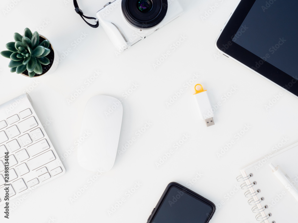 top view of office desk table with notebook, plastic plant, digital camera and keyboard on white background, graphic designer, Creative Designer concept. top view of office desk table with notebook, plastic plant, digital camera and keyboard on white background, graphic designer, Creative Designer concept.