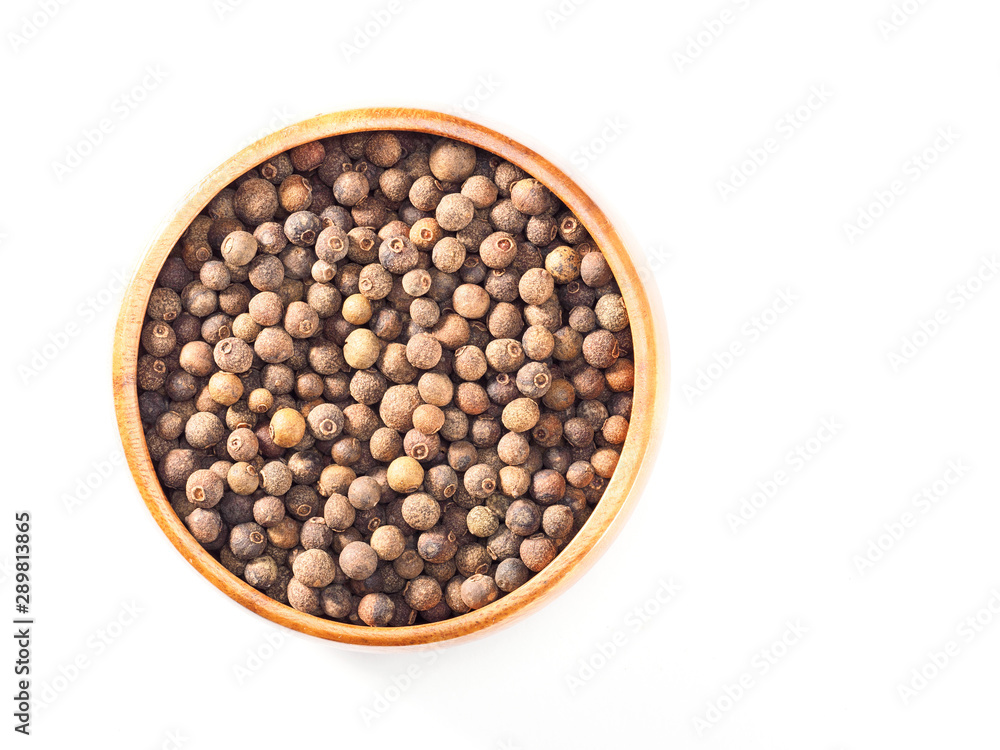 Allspice (Jamaica pepper) in wooden cup on the white background Allspice (Jamaica pepper) in wooden cup on the white background