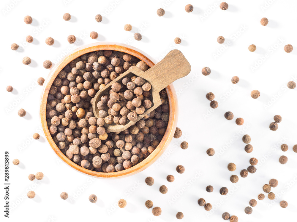 Allspice (Jamaica pepper) in wooden cup and scoop on white background Allspice (Jamaica pepper) in wooden cup and scoop on white background
