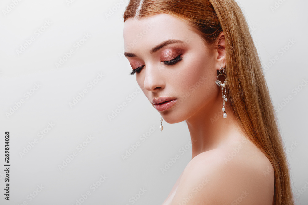 Naklejka premium Portrait of young tender redhead teenage girl with healthy freckled skin. Caucasian woman model with ginger hair posing indoors