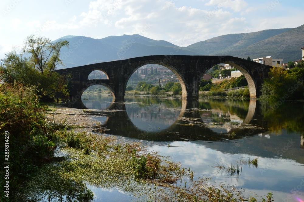 Fototapeta premium reflection of a stone bridge in a river