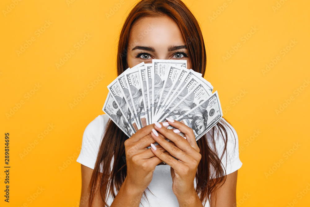 Portrait of a young girl, with banknotes isolated on a yellow background Portrait of a young girl, with banknotes isolated on a yellow background