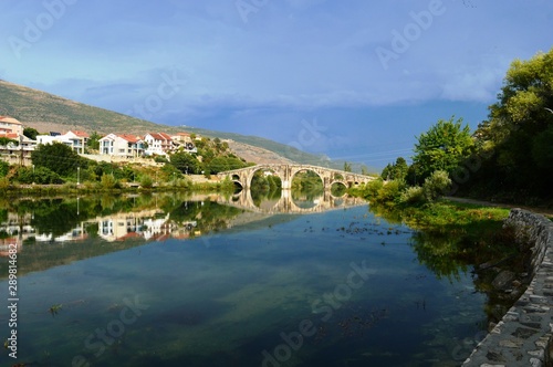 reflection of a stone bridge in a river