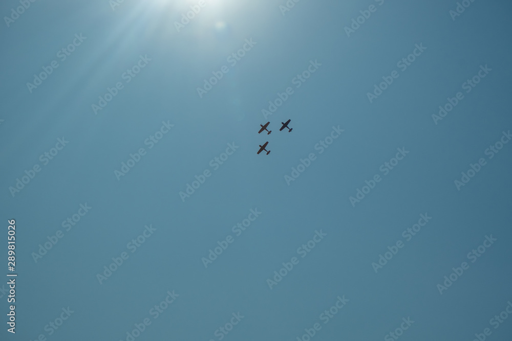 Demonstration performance of an aerobatic team of three aircraft. Smoke traces from airplanes in the blue sky. Demonstration performance of an aerobatic team of three aircraft. Smoke traces from airplanes in the blue sky.